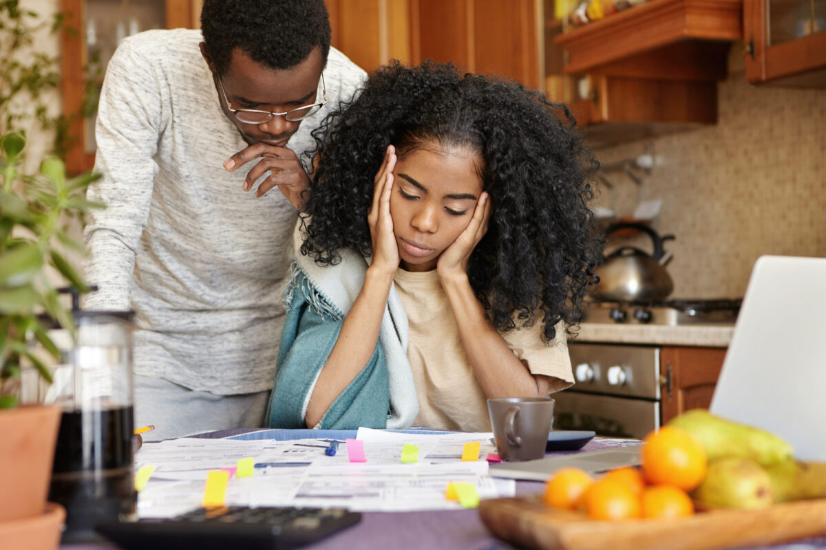 unhappy young african could looking stressed depressed while calculating bills home