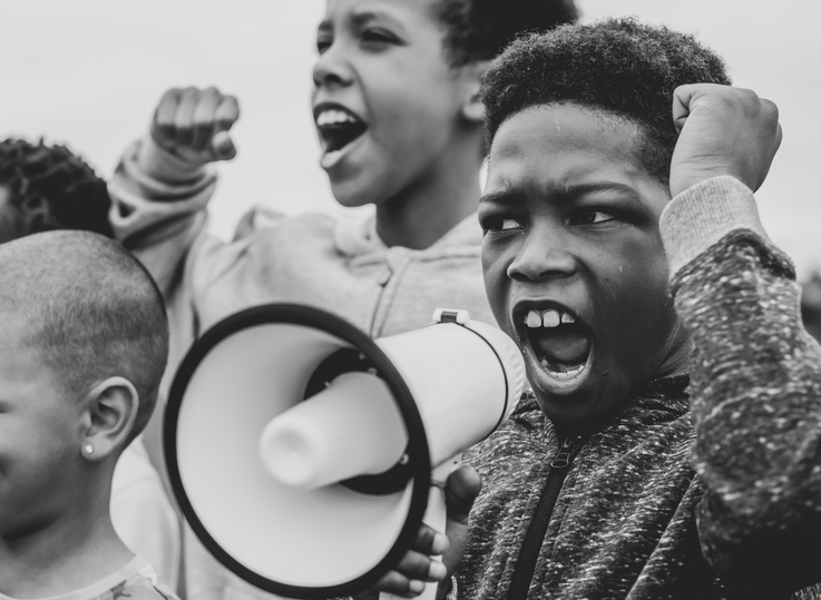 young boy shouting megaphone protest